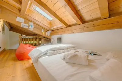 two large beds in a room with wooden ceilings at Appartement Des Granges - Happy Rentals in Chamonix-Mont-Blanc
