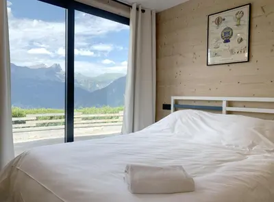 a bed in a bedroom with a large window at Chalet Le Splendide in Saint-Gervais-les-Bains