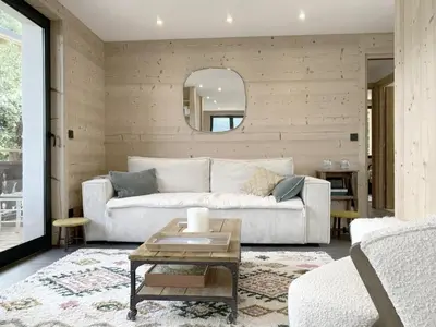 a living room with a white couch and a mirror at Chalet Le Splendide in Saint-Gervais-les-Bains