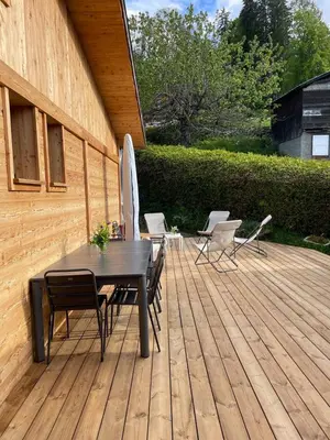 a patio with a table and chairs on a wooden deck at Chalet Le Splendide in Saint-Gervais-les-Bains