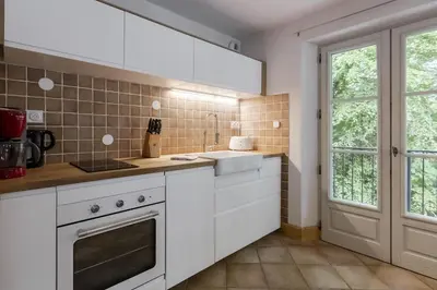 a kitchen with white cabinets and a window at Le Montagnard in Saint-Gervais-les-Bains