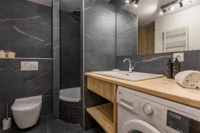 a bathroom with a sink and a washing machine at Le Montagnard in Saint-Gervais-les-Bains