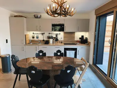 a kitchen with a large wooden table and chairs at L'Olympe de Combloux - Terrasse & balcon sur la forêt in Combloux