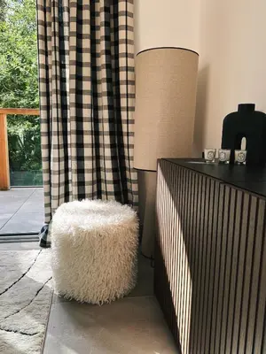 a living room with a lamp and a white stool at L'Olympe de Combloux - Terrasse & balcon sur la forêt in Combloux