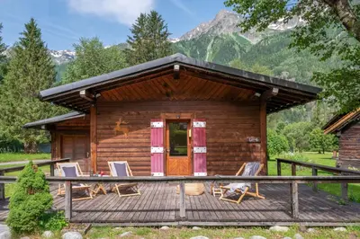 a log cabin with chairs on a deck at Cocooning small chaming chalet with garden in Chamonix-Mont-Blanc