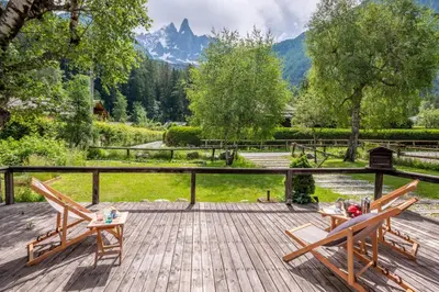 a deck with two chairs and a view of a mountain at Cocooning small chaming chalet with garden in Chamonix-Mont-Blanc