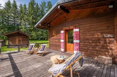 a wooden deck with chairs and a cabin at Cocooning small chaming chalet with garden in Chamonix-Mont-Blanc