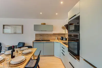 a kitchen with a wooden table with chairs and appliances at Apartment Cristal des Glaces, Mont Blanc View, Alpes Travel, sleeps 6 in Chamonix-Mont-Blanc
