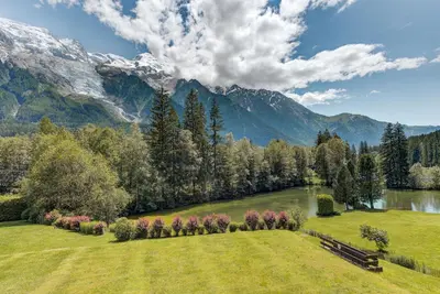 a park with a bench and a lake and mountains at Apartment Cristal des Glaces, Mont Blanc View, Alpes Travel, sleeps 6 in Chamonix-Mont-Blanc