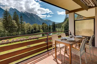 a table and chairs on a balcony with a view at Apartment Cristal des Glaces, Mont Blanc View, Alpes Travel, sleeps 6 in Chamonix-Mont-Blanc