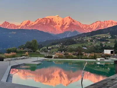 a swimming pool with a mountain range in the background at standing 4 étoiles in Demi-Quartier