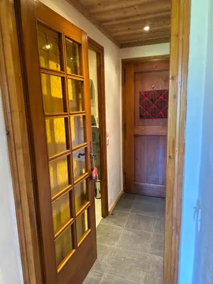 a hallway with a wooden door and a wooden door at standing 4 étoiles in Demi-Quartier