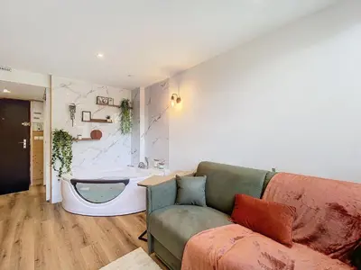 a living room with a couch and a bath tub at Le Cocon de Chamonix in Chamonix-Mont-Blanc