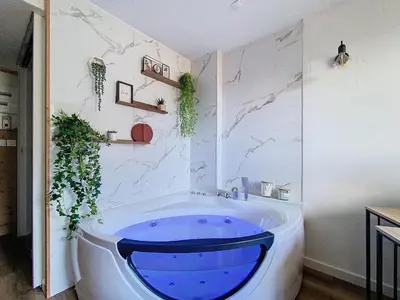 a bathroom with a large blue tub in a room at Le Cocon de Chamonix in Chamonix-Mont-Blanc
