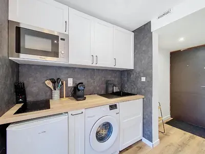 a kitchen with a washing machine and a microwave at Le Cocon de Chamonix in Chamonix-Mont-Blanc