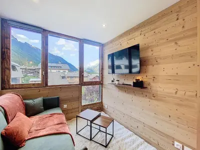 a living room with a couch and a flat screen tv at Le Cocon de Chamonix in Chamonix-Mont-Blanc