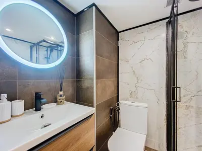 a bathroom with a toilet and a sink and a mirror at Le Cocon de Chamonix in Chamonix-Mont-Blanc