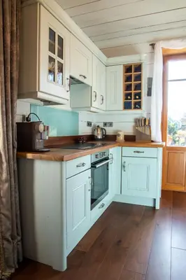 a kitchen with white cabinets and a wooden floor at Heart of Chamonix Lovely and cosy 2 bedrooms, terrace, parking in Chamonix-Mont-Blanc