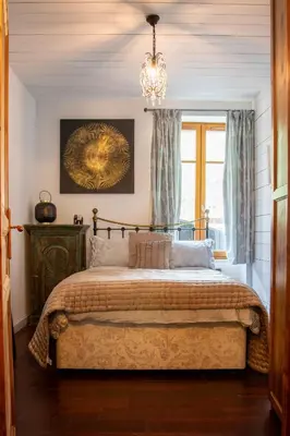 a bedroom with a bed with a chandelier and a window at Heart of Chamonix Lovely and cosy 2 bedrooms, terrace, parking in Chamonix-Mont-Blanc