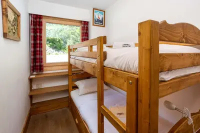 a bedroom with two bunk beds and a window at Le Brevent 2 Apartment - Chamonix All Year in Chamonix-Mont-Blanc