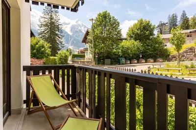a balcony with two chairs and a view of a mountain at Le Brevent 2 Apartment - Chamonix All Year in Chamonix-Mont-Blanc