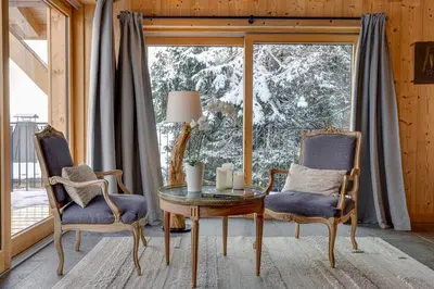 a room with a table and two chairs and a window at Chalet Ciscana Chamonix MontBlanc in Chamonix-Mont-Blanc