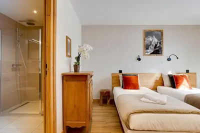 a living room with two beds and a shower at Chalet Ciscana Chamonix MontBlanc in Chamonix-Mont-Blanc