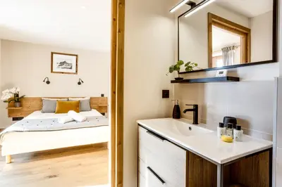 a bathroom with a sink and a bed in a room at Chalet Ciscana Chamonix MontBlanc in Chamonix-Mont-Blanc