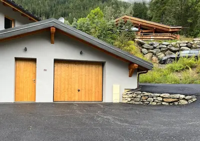 a garage with two brown doors on a house at Chalet Ciscana Chamonix MontBlanc in Chamonix-Mont-Blanc