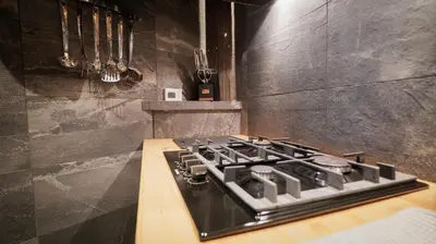 a kitchen with a stove and a counter top at Lodge plein pied avec jardin à 10min de Chamonix in Servoz