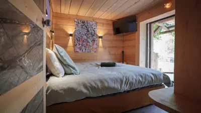 a bedroom with a bed in a wooden cabin at Lodge plein pied avec jardin à 10min de Chamonix in Servoz