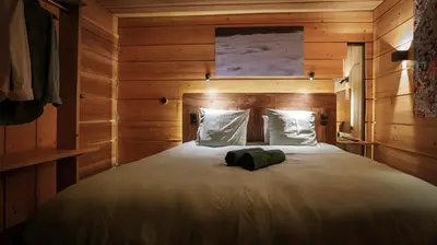 a bedroom with a large bed with wooden walls at Lodge plein pied avec jardin à 10min de Chamonix in Servoz