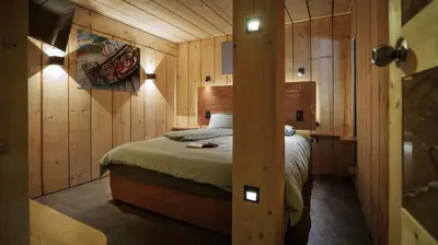 a bedroom with a bed in a room with wooden walls at Lodge plein pied avec jardin à 10min de Chamonix in Servoz