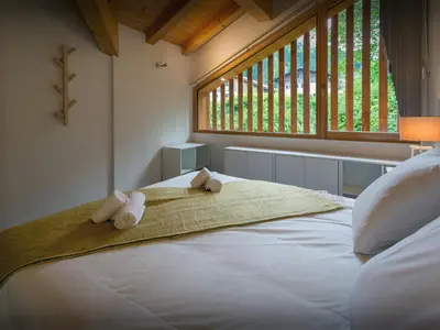 a bedroom with a large white bed with towels on it at Chalet Morris - OVO Network in Sixt