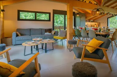 a living room with couches and tables and a bar at MontCriou - OVO Network in Samoëns