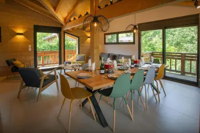 a dining room with a wooden table and chairs at MontCriou - OVO Network in Samoëns