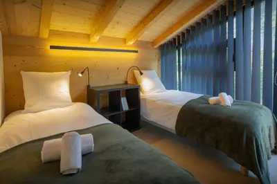 two beds in a room with windows at MontCriou - OVO Network in Samoëns