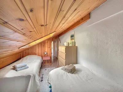 two beds in a room with a wooden ceiling at LUTB17 - Duplex 6 personnes au pied des pistes in Les Carroz d'Araches