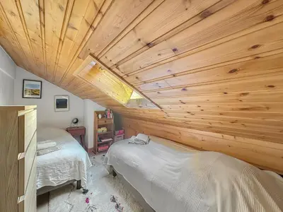 a bedroom with two beds and a wooden ceiling at LUTB17 - Duplex 6 personnes au pied des pistes in Les Carroz d'Araches