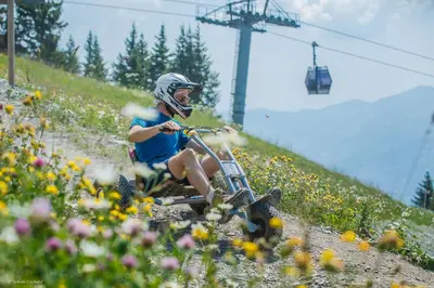 a person riding a bike down a hill with flowers at LUTB17 - Duplex 6 personnes au pied des pistes in Les Carroz d'Araches