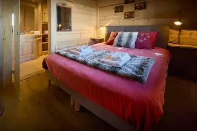 a bedroom with a red bed with towels on it at Chalet Vardache - OVO Network in Cordon
