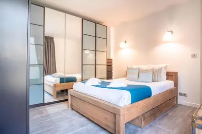 a bedroom with a large bed and a mirror at Appt Daisy - Familial - Calme - Vues in Chamonix-Mont-Blanc