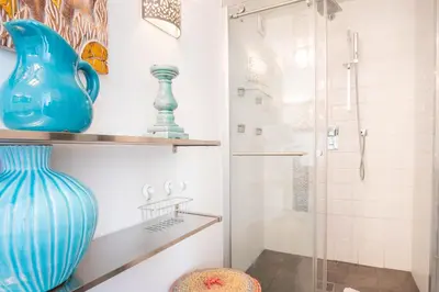 a bathroom with a glass shower and a blue vase at Appt Daisy - Familial - Calme - Vues in Chamonix-Mont-Blanc