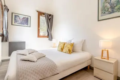 a bedroom with a bed with white sheets and a window at Appt Donna - Chamonix Centre in Chamonix-Mont-Blanc