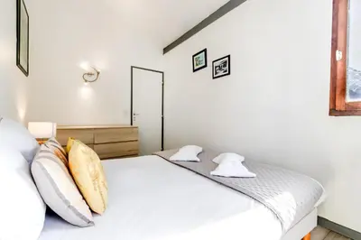 a bedroom with a bed with white sheets and pillows at Appt Donna - Chamonix Centre in Chamonix-Mont-Blanc