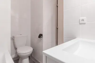 a white bathroom with a toilet and a sink at Appt Donna - Chamonix Centre in Chamonix-Mont-Blanc