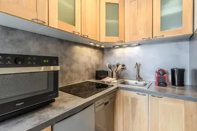 a kitchen with wooden cabinets and a stove and a sink at Appt Donna - Chamonix Centre in Chamonix-Mont-Blanc