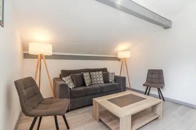 a living room with a couch and a table and chairs at Appt Donna - Chamonix Centre in Chamonix-Mont-Blanc