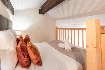 a bedroom with a bed with pillows on a balcony at Triplex - Hypercentre - Balcon avec vue montagnes in Chamonix-Mont-Blanc