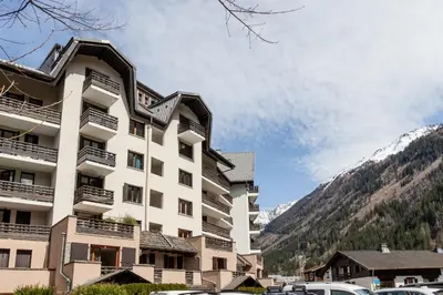 a large building with cars parked in front of it at Triplex - Hypercentre - Balcon avec vue montagnes in Chamonix-Mont-Blanc
